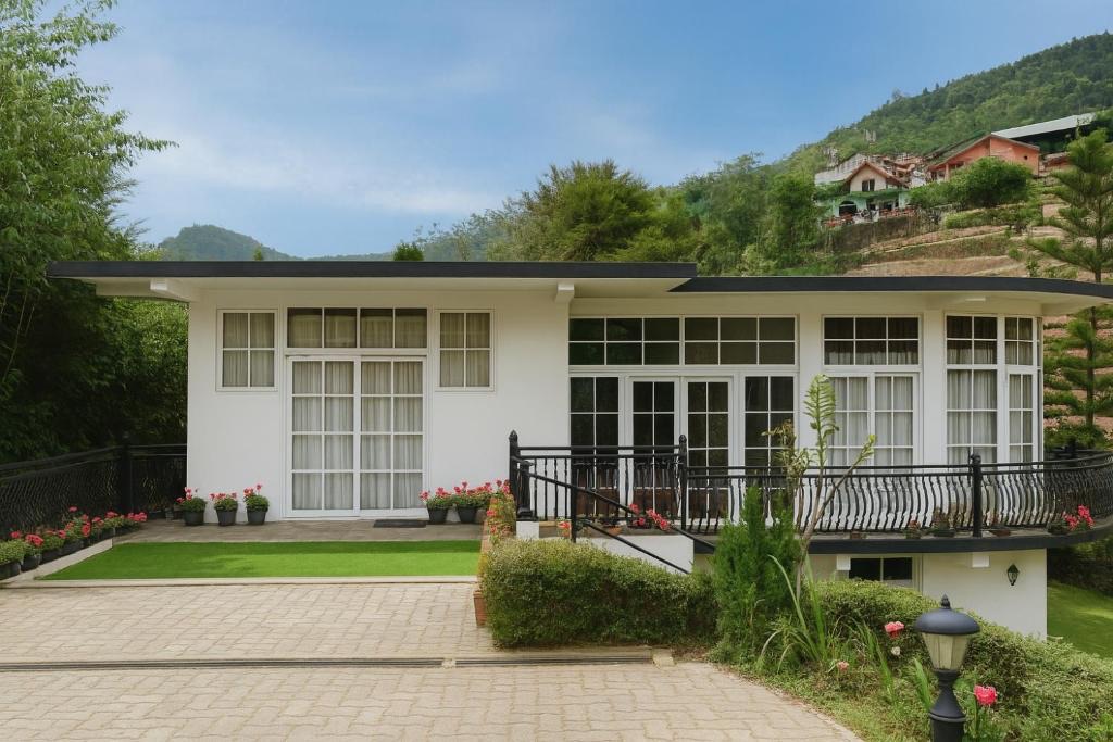 The white Ceylon Lodge villa surrounded by green hills
