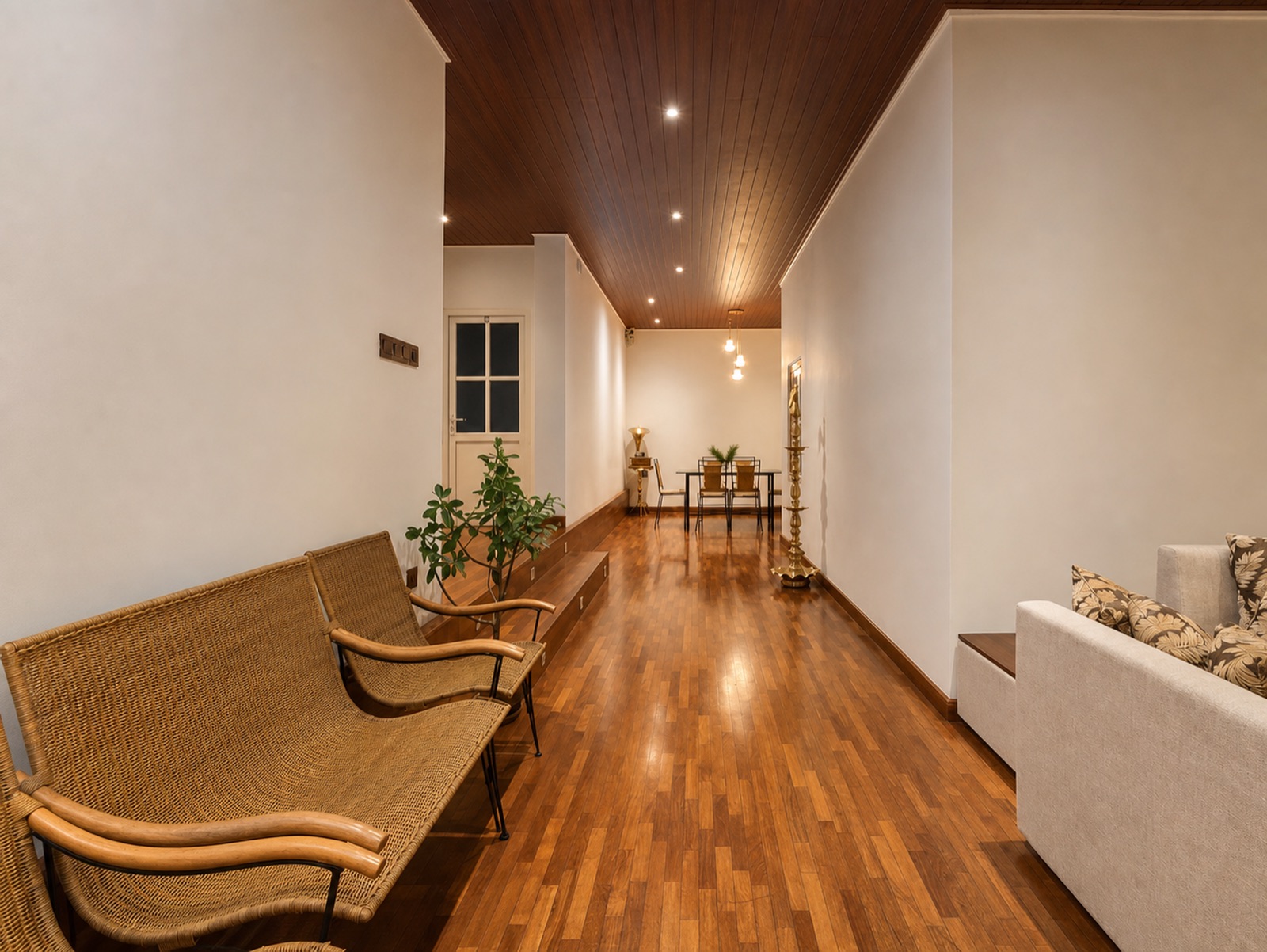 The warm dining corridor with teak floors and a traditional brass oil lamp